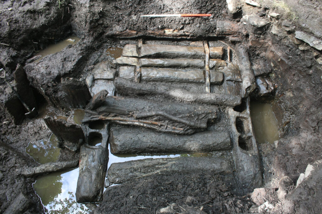 The phase 1 entrance to roundhouse ST2 showing the log surface and mortised beams on either side The phase 1 entrance to roundhouse ST2 showing the log surface and mortised beams on either side