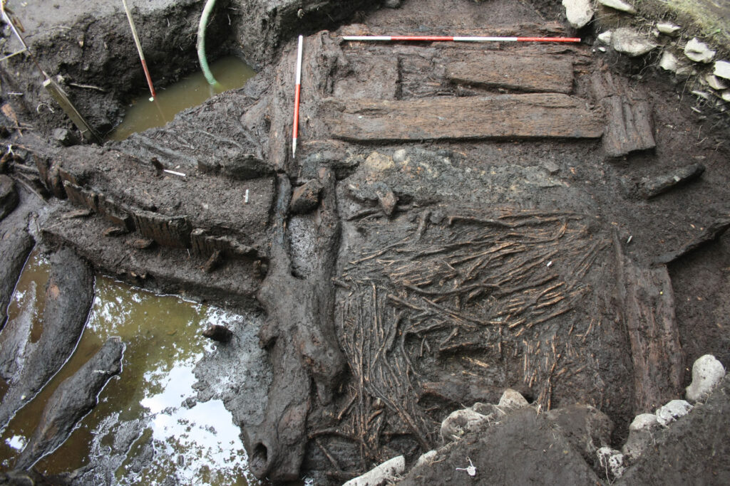 The phase 2 entrance to roundhouse ST2 showing oak planks on the inside and brushwood bundles on the outside of plank walls The phase 2 entrance to roundhouse ST2 showing oak planks on the inside and brushwood bundles on the outside of plank walls.