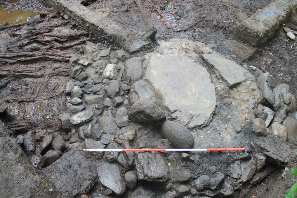 Slab hearth from inside roundhouse ST2 showing a kerb of rounded stones Slab hearth from inside roundhouse ST2 showing a kerb of rounded stones