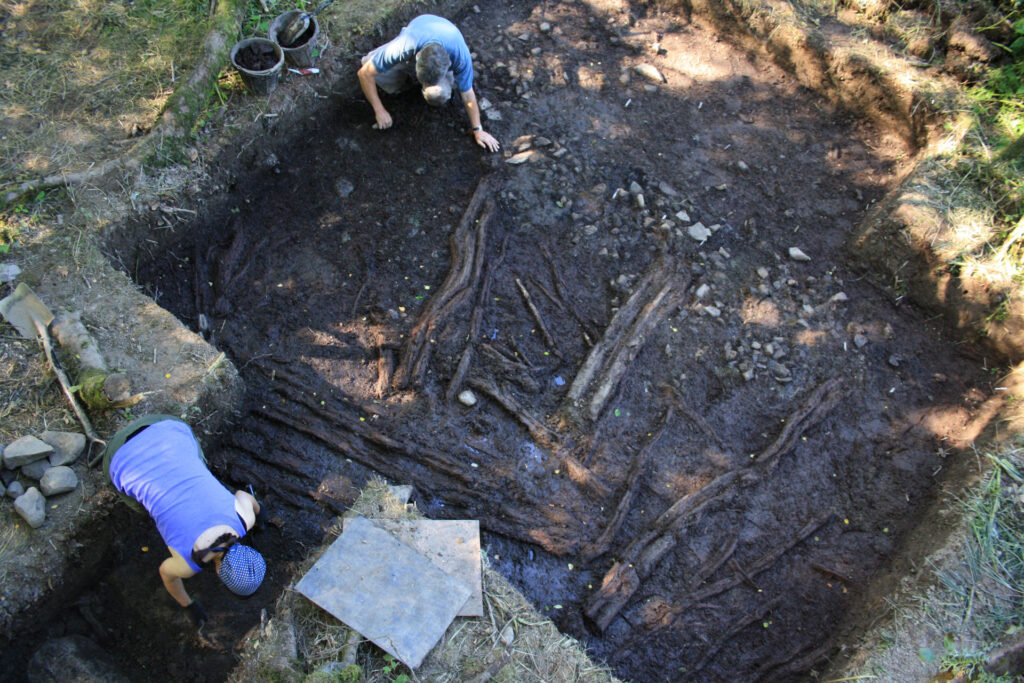 Archaeologists excavating the radial timber and brushwood floor of roundhouse ST1 Archaeologists excavating the radial timber and brushwood floor of roundhouse ST1