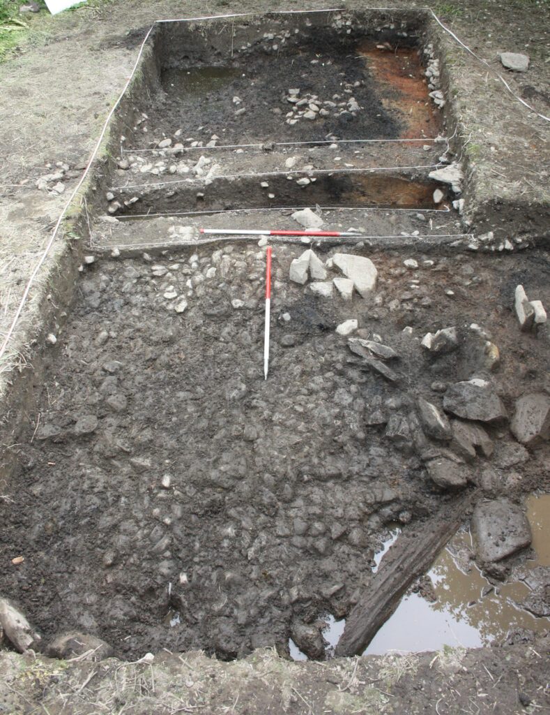 Cobbled surface near the entrance with Rampart 2 defined by orange sand in the back Cobbled surface near the entrance with Rampart 2 defined by orange sand in the back