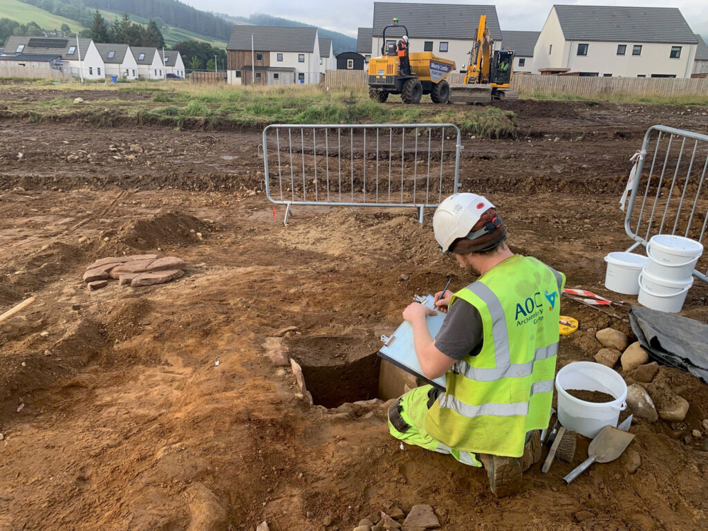 An archaeologist excavates a Bronze Age cist An archaeologist excavates a Bronze Age cist